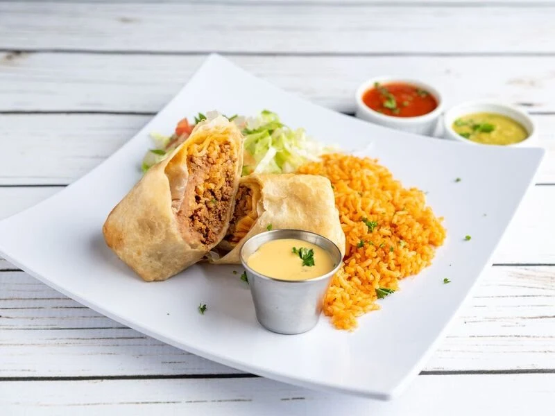Beef Chimichanga Plate - Crispy fried burrito filled with savory beef, topped with queso.