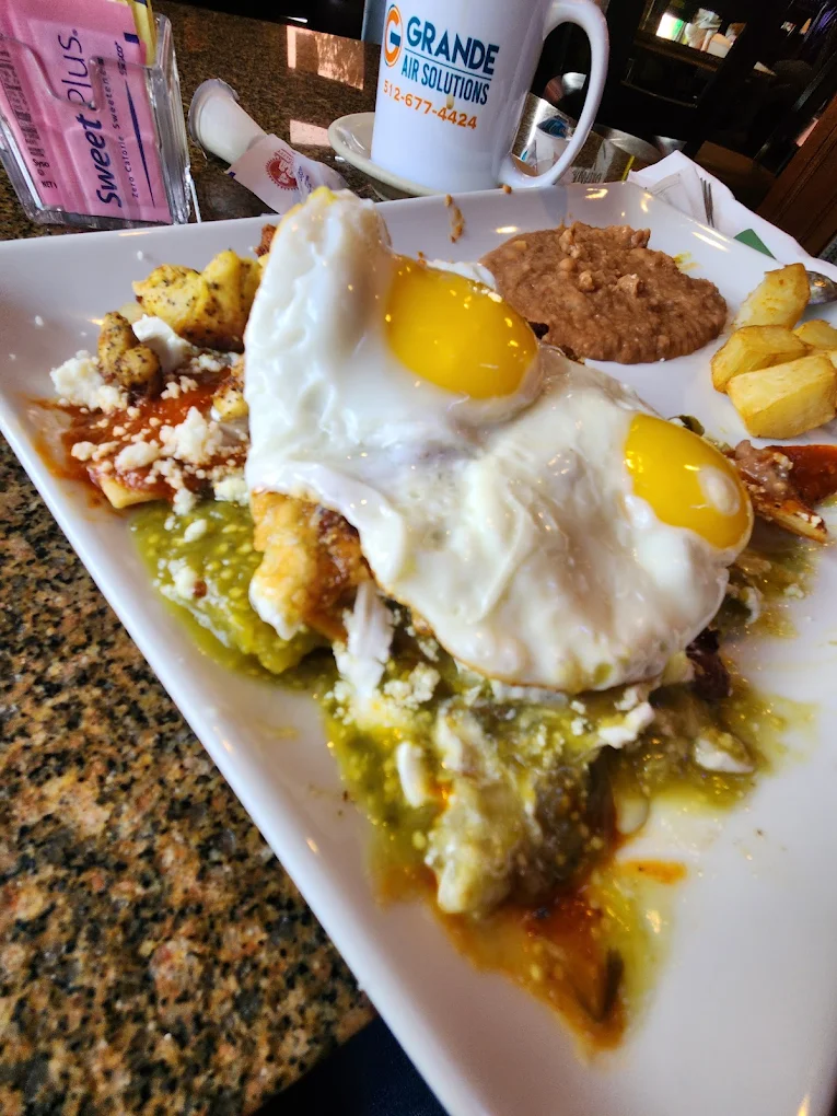 Chilaquiles - Crispy tortilla chips simmered in salsa verde or roja, topped with eggs and cheese